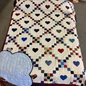 Handmade Amish 9 Patch Hearts quilt in Queen size featuring colorful pieced blocks, appliqué hearts, detailed hand stitching, and blue scalloped border from Lancaster County