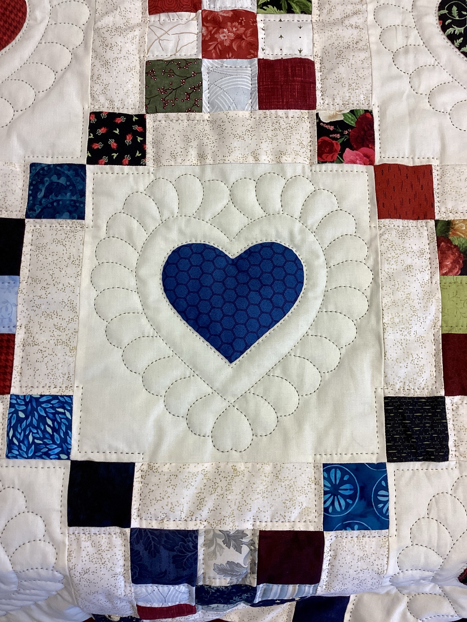 Handmade Amish 9 Patch Hearts quilt in Queen size featuring colorful pieced blocks, appliqué hearts, detailed hand stitching, and blue scalloped border from Lancaster County