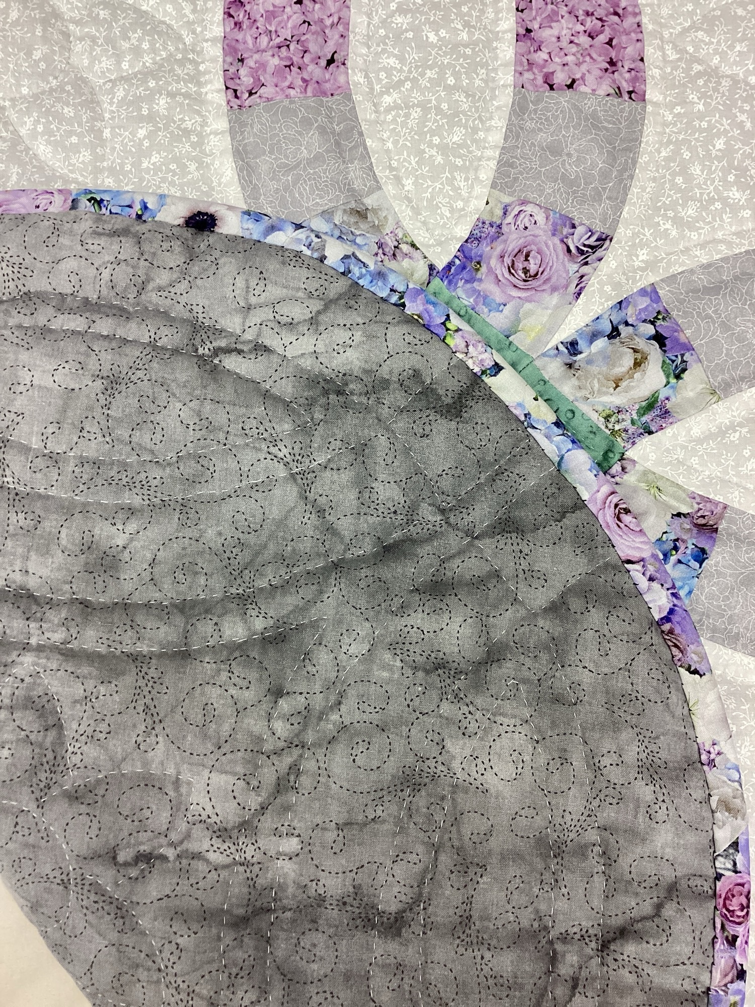 Backing of Handmade Amish Double Wedding Ring quilt throw in sage green and lavender floral fabric