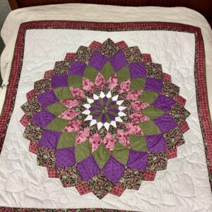 Handmade Lancaster County Giant Dahlia throw quilt featuring layered floral petals in purple and green with detailed hand quilting