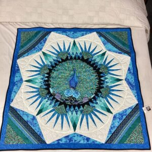 Hand-stitched peacock wall hanging featuring batik and peacock feather fabrics