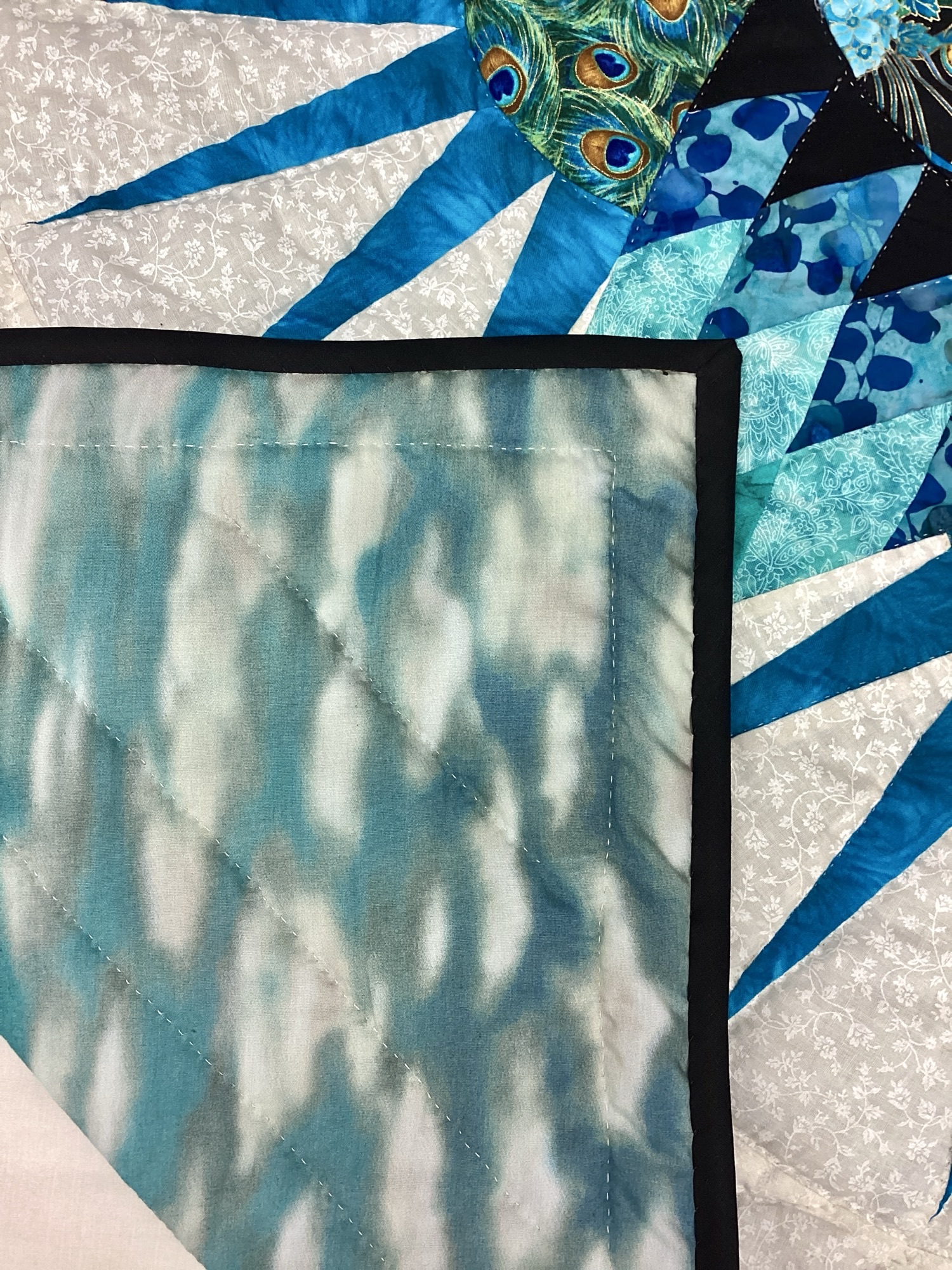 Backing of Lancaster County Mennonite peacock quilt with geometric starburst design