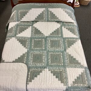 Handmade Lancaster County Log Cabin Star quilt with sage green floral fabrics, cream background, and leafy vine border