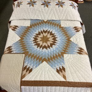 Handmade Lancaster County Amish Lone Star quilt with floating cream, sky blue and brown star design, feather quilting and floral backing