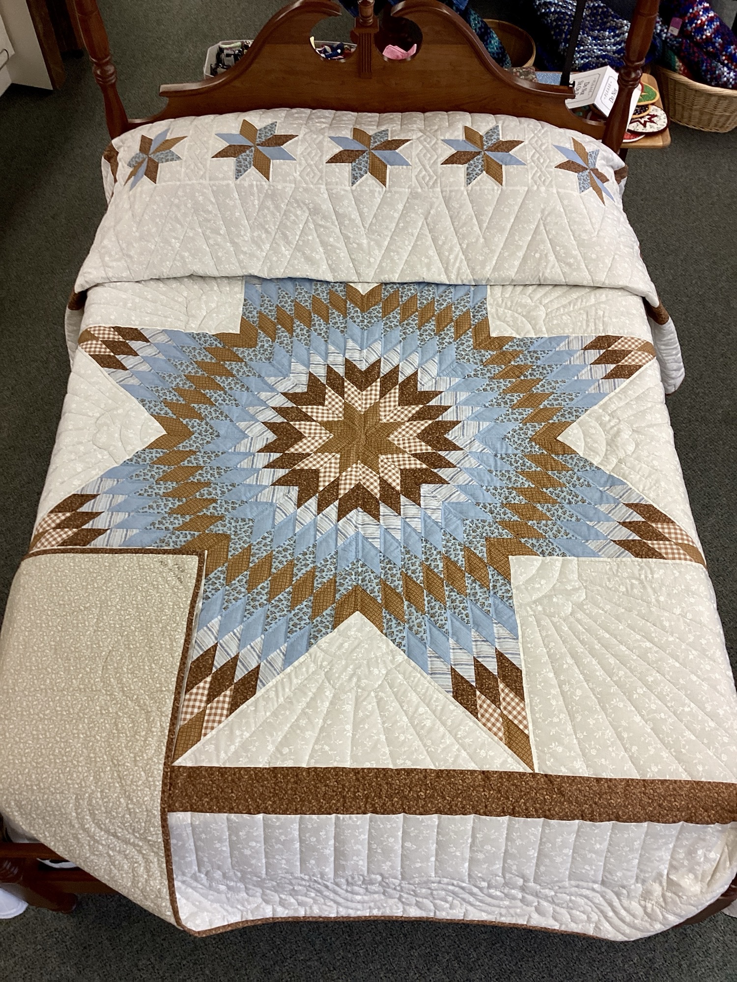 Handmade Lancaster County Amish Lone Star quilt with floating cream, sky blue and brown star design, feather quilting and floral backing