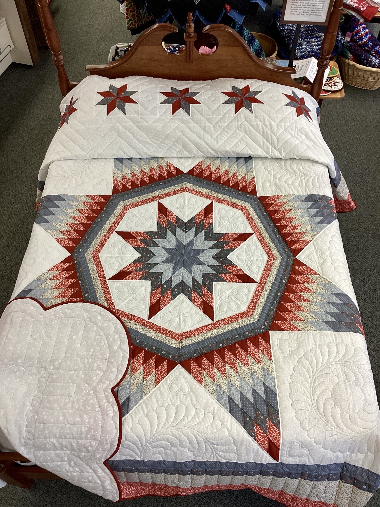 Handmade Lancaster County Amish Maryland Star quilt with red, white and gray center star, octagon border, feather quilting and scalloped edges