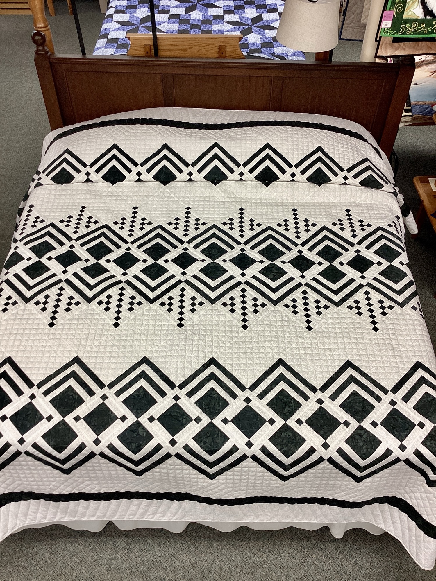 Handmade Lancaster County Mennonite Queen of Diamonds quilt with black printed geometric diamond pattern on ivory printed background and hand quilting