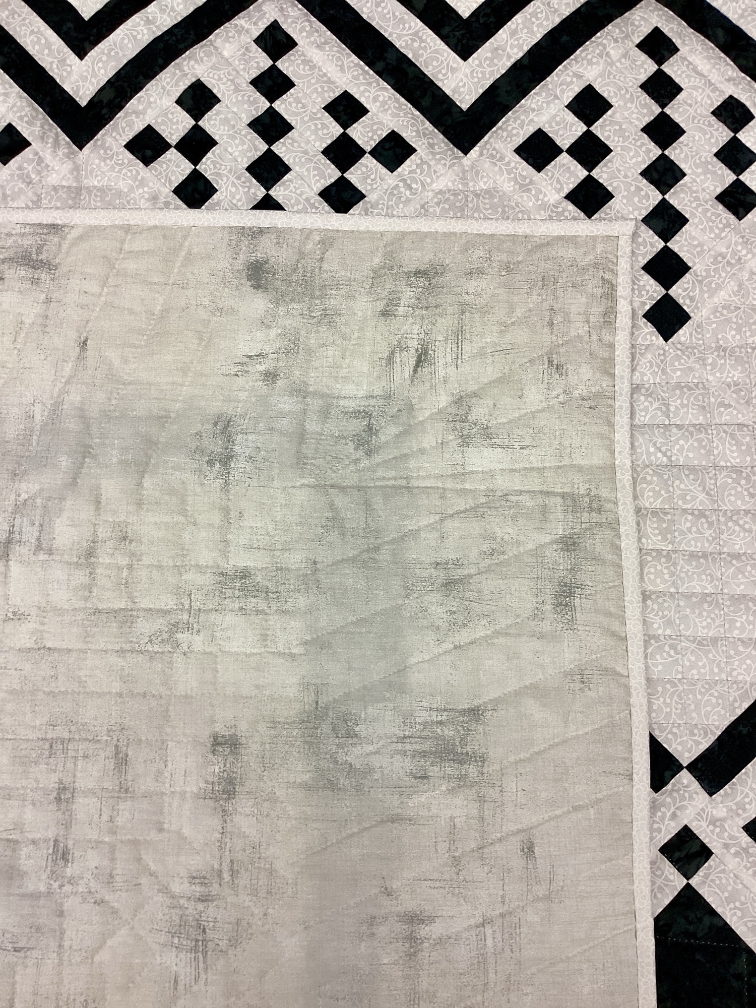 Close-up of backing on the black and cream tonal Queen of Diamonds quilt.