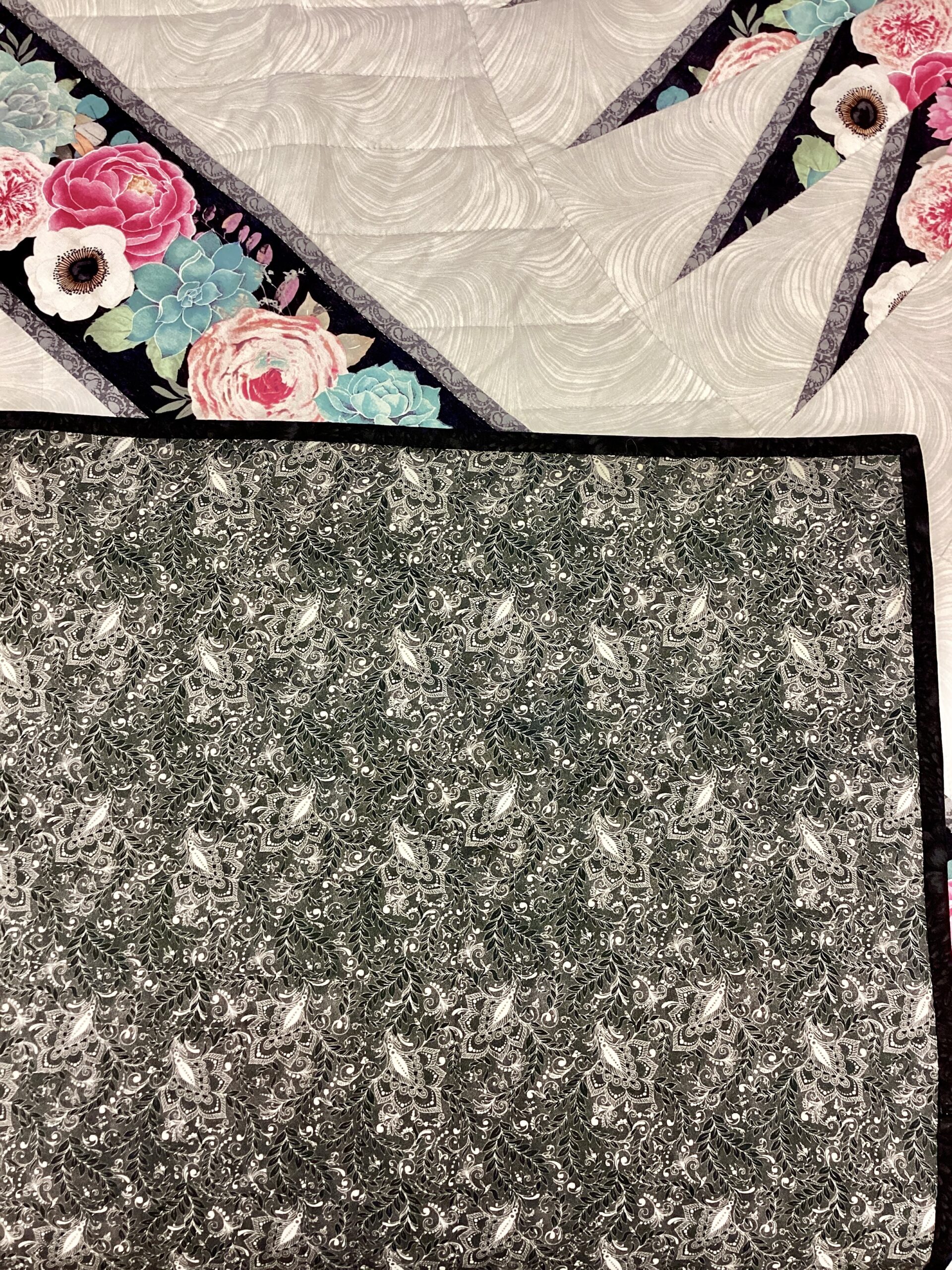 Black floral backing on Handmade Lancaster County Amish Sawtooth Medallion quilt.