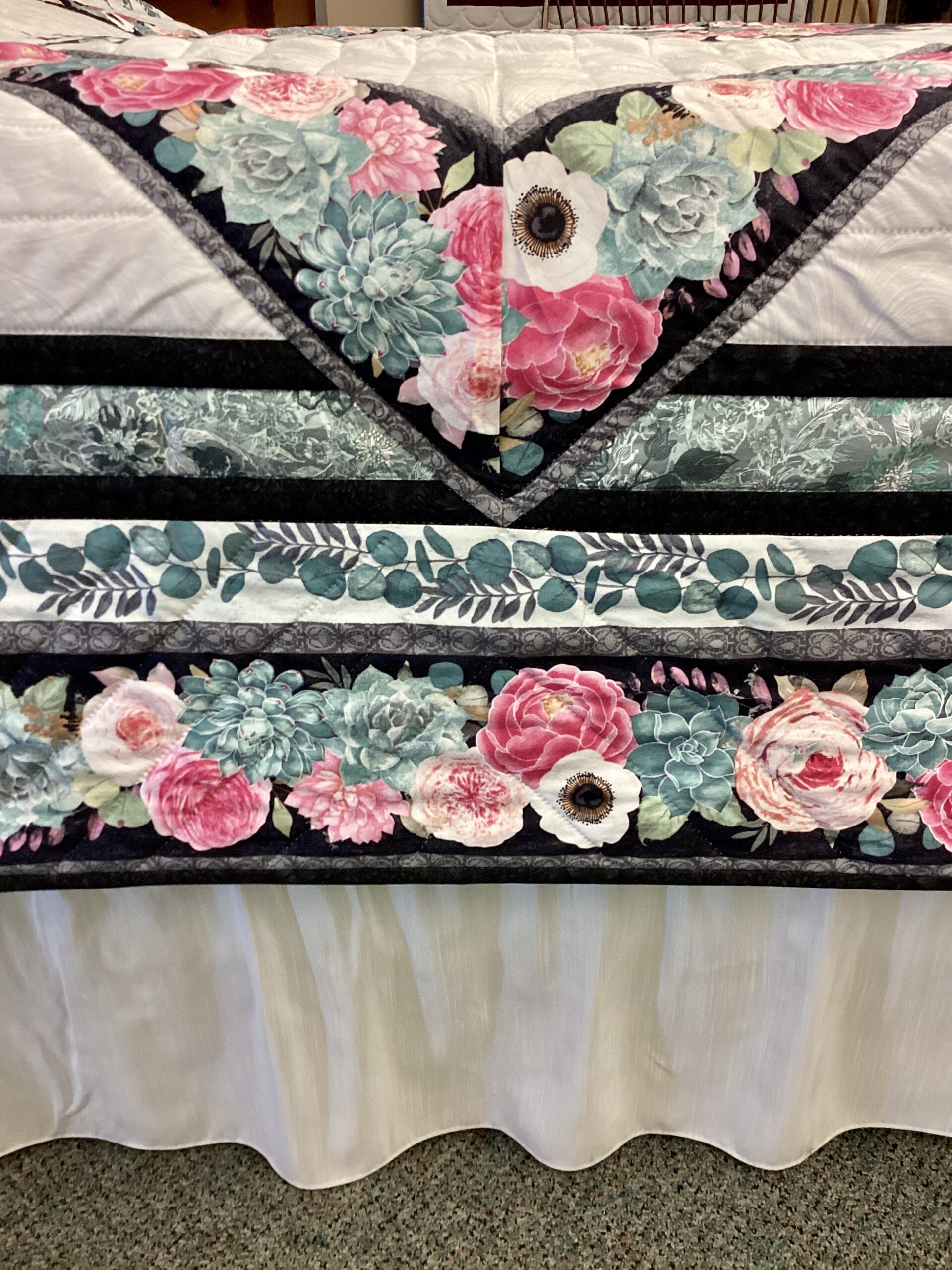Close up of detail on Sawtooth Medallion Amish Quilt with floral fabric