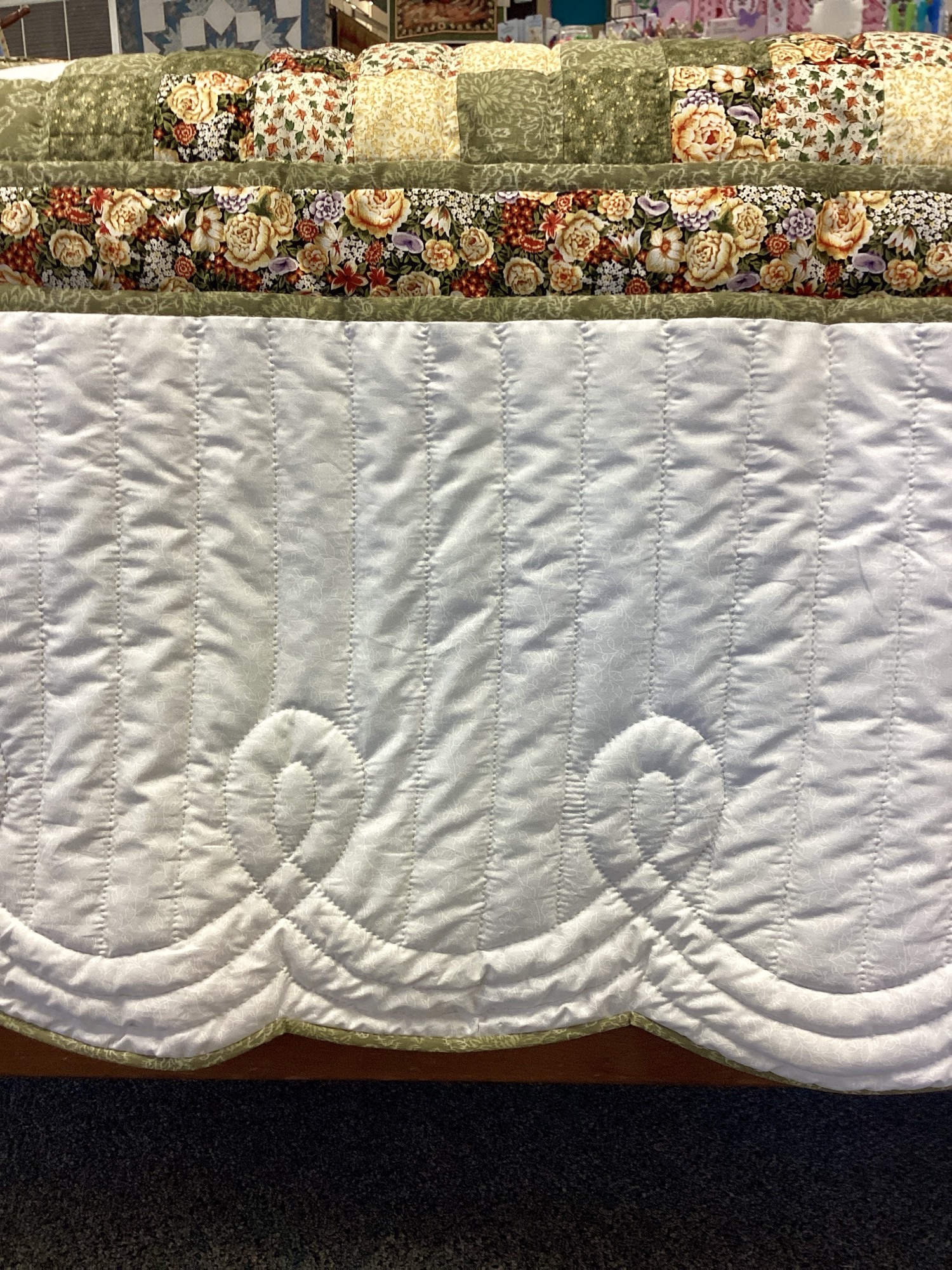 Hand-quilted floral motif inside white setting square on handmade Star N Common quilt