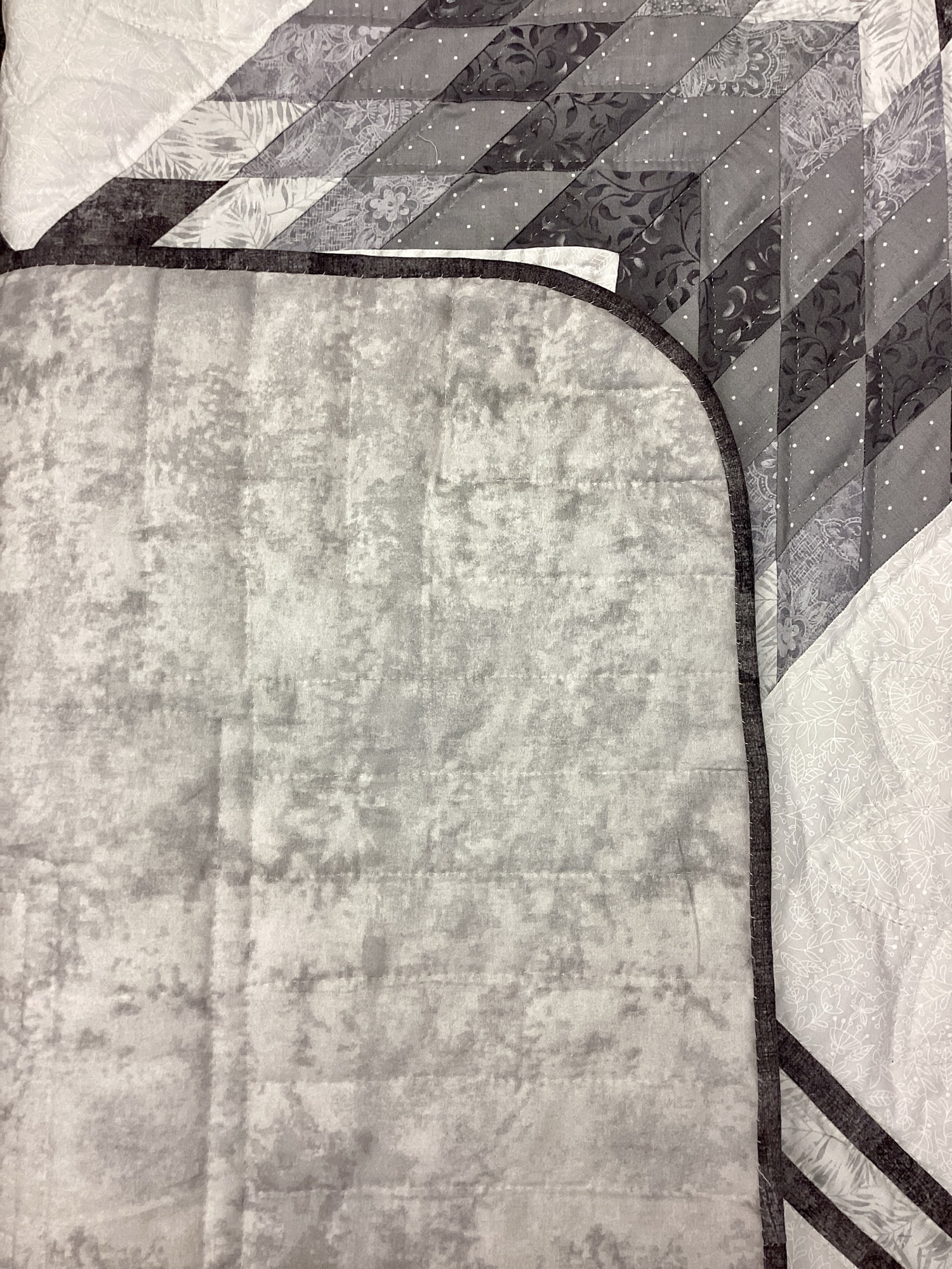 Gray marble backing fabric with dark gray binding on handmade Star N Common Mennonite quilt